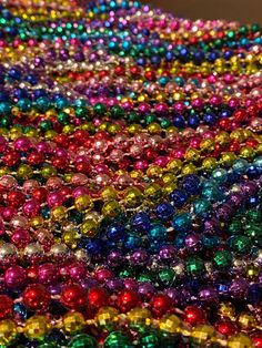 many different colored beads laying on top of each other in the same color and pattern