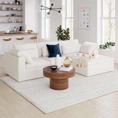 a living room with white furniture and wood flooring