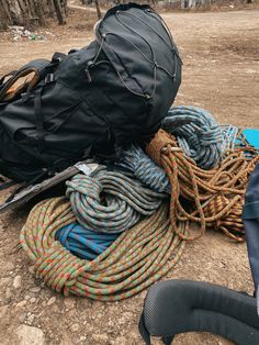 there are many ropes and bags on the ground next to each other, including a backpack