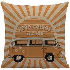 an orange and white pillow with the words here comes the sun in front of a van