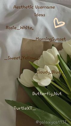 a bouquet of white tulips sitting on top of a brown paper wrapper