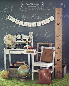 a room with a desk, chair and large ruler on the wall that says bee vintage