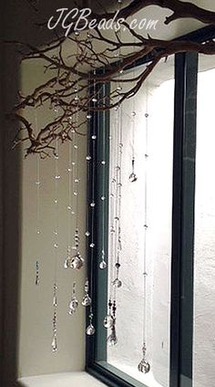 a bathroom with a tree branch hanging over the bathtub, and glass beads on the shower curtain