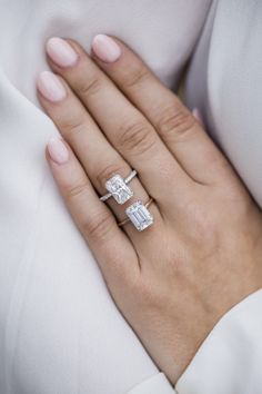 a woman's hand with two rings on it