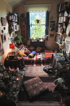 a living room filled with lots of furniture and bookshelves next to a window