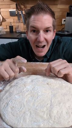 a man is making pizza dough in the kitchen