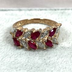 This ring has 2 tiny natural diamonds but gives the illusion of having 8! The 6 marquise cut simulated rubies have a beautiful red color and measure 4.6x2.3mm, totaling well over 3/4 carats. This is a great ring to wear on vacations when you want to leave the real thing at home! Size 7.75 Shank is 2.6mm Marquise Red Diamond Ring, Red Ruby Ring With Marquise Cut Diamond, Red Marquise Ruby Ring With Prong Setting, Red Marquise Diamond Ring Fine Jewelry, Red Marquise Cut Diamond Ring - Fine Jewelry, Red Marquise Cut Diamond Ring, Red Marquise Rings With Diamond Accents, Red Marquise Ring With Diamond Accents, Red Marquise Diamond Accent Rings