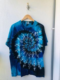 a blue tie - dyed shirt hanging on a wall