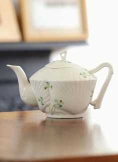 a white tea pot sitting on top of a wooden table