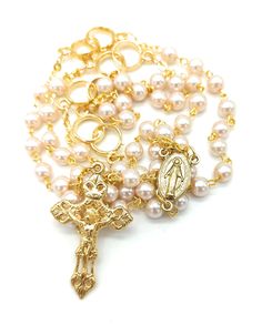 a rosary with an image of jesus on the cross is shown in gold and pearls