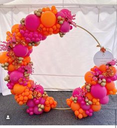 an orange and pink balloon wreath on display