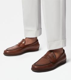 Characterized by a rubber pebble outsole and an elegant woven piping, these loafers are crafted in calfskin leather. Featuring a classic penny bar and the stamped Tod's monogram, they interpret a refined urban taste. Brown Calf Leather Loafers With Textured Sole, Classic Boat Shoes With Textured Moc Toe, Classic Boat Shoes With Textured Sole And Moc Toe, Classic Brown Loafers With Textured Sole, Classic Brown Moccasins With Textured Sole, Timeless Brown Leather Shoes With Textured Sole, Brown Leather Shoes With Textured Sole, Classic Moccasins With Textured Sole, Classic Slip-on Boat Shoes With Textured Sole