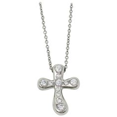 Simply stunning modernized diamond cross pendant necklace designed by Elsa Peretti for Tiffany & Co.. The delicate cross motif is embellished with glittering Tiffany diamonds, while the finely woven platinum chain gently hugs the neck. This keepsake is truly a classic that will never go out of style. This gorgeous necklace from Tiffany & Co. features a single three-dimensional platinum cross arranged a delicate chain. The cross is designed in a rounded, contemporary style and is embellished with Luxury White Gold Cross Necklace, Luxury Diamond White Cross Pendant Necklace, Luxury White Gold Cross Necklace With Diamond Accents, Luxury Diamond White Cross Necklace, Luxury Crucifix Cross Necklace For Formal Occasions, Luxury Cross Necklace With Diamond Accents, Luxury Silver Cross Necklace With Diamond Accents, Elegant Silver Cross Diamond Necklace, Elegant Cross Necklace With Diamond Accents In Cubic Zirconia