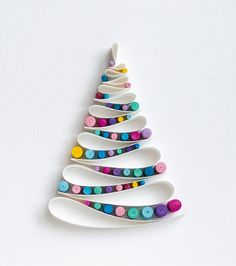 a christmas tree made out of spoons on a white surface with colorful buttons attached to it