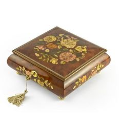 an ornately decorated wooden box with gold trimmings and flowers on the lid