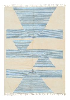 a blue and white rug with fringes on the bottom, in an abstract pattern