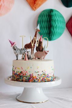 a birthday cake decorated with animals and decorations