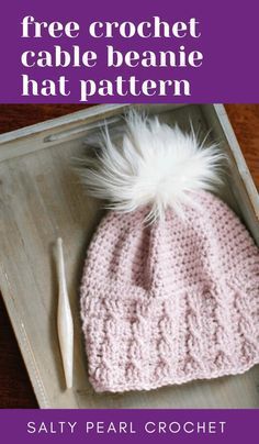 a crocheted hat with a white pom - pom on top and the words free crochet cable beanie hat pattern