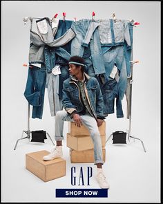 a man sitting on top of a box next to clothes