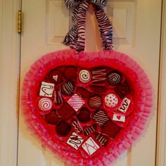 a valentine's day wreath made out of candy on the front door with a zebra print bow