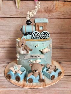 a blue cake decorated with teddy bears and a train