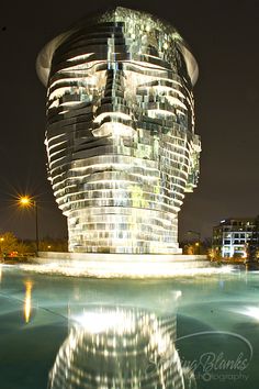 a large building that is next to a body of water with lights on the side