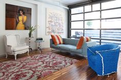 a living room filled with furniture and a painting on the wall next to a window