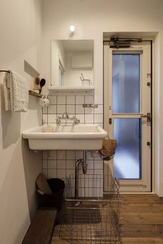 a white sink sitting under a bathroom mirror next to a wooden counter top oven mitts