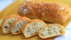 four loaves of bread sitting on top of a yellow napkin