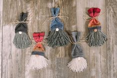 four knitted gnome mitts tied together on a wooden floor with string and twine