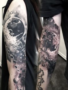 a man's arm covered in black and white ink with an image of the moon