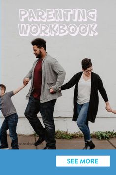 a man and woman holding hands while walking with two small children in front of a white wall