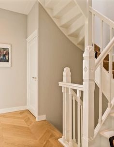 a white staircase with wooden handrails in a home's entryway area