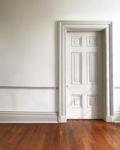 an empty room with white walls and wooden floors