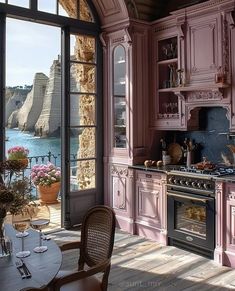 a kitchen with pink cabinets and an ocean view