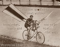 an old photo of a man riding a bike with a kite attached to it