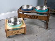 two stainless steel bowls sitting on top of a wooden stand next to a sign that says rusty