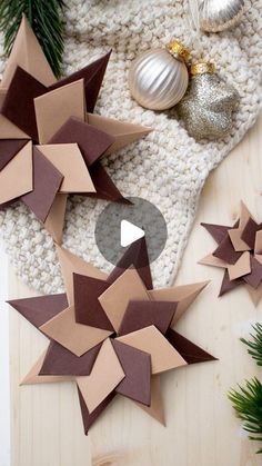 some paper stars are laying on the floor next to christmas decorations and ornaments, with one being cut out