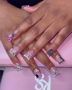 a woman's nails with pink and silver designs on them, including the letter k