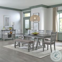 a dining room table and chairs with a bench in front of the table on a rug