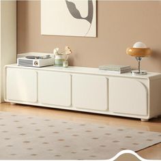 a white entertainment center in a living room with beige walls and rugs on the floor