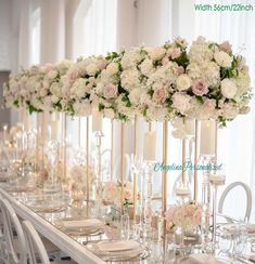 a long table with white flowers and candles