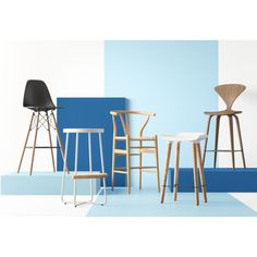 four different chairs and stools in front of a blue, white, and grey wall