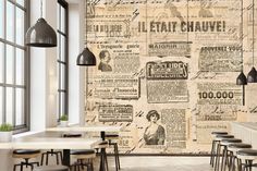 an old newspaper wallpaper in a restaurant with tables and stools around the table