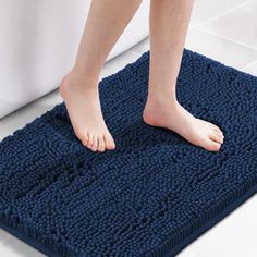 a person standing on a bath mat in the bathroom