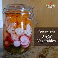 a jar filled with veggies sitting on top of a counter