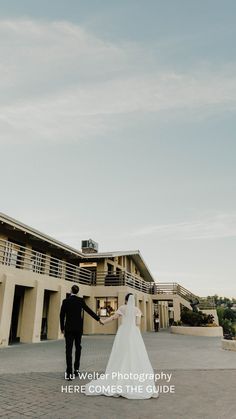 a bride and groom holding hands in front of a building with the words, life will tell photography here comes the guide