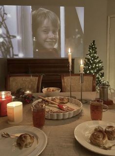 a table topped with plates and food next to a christmas tree in front of a flat screen tv