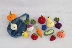 small crocheted fruits and vegetables sitting on top of a white wooden table next to each other