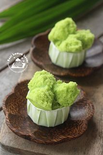 two bowls filled with green ice cream sitting on top of a wooden plate next to another bowl